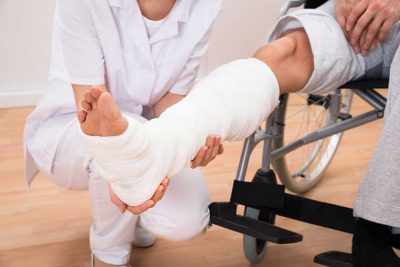 Nurse holding injured right leg with plaster cast, workers compensation